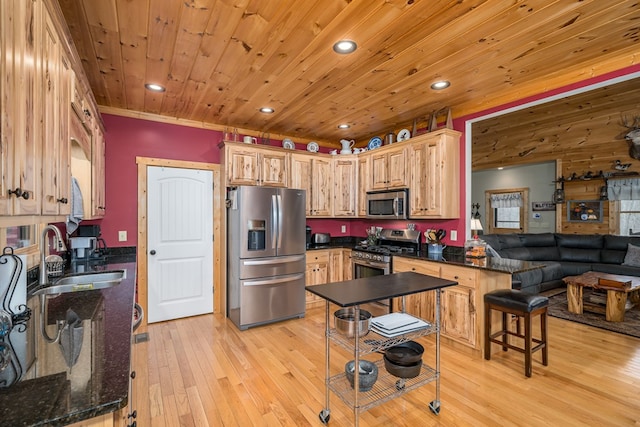 kitchen with stainless steel appliances, light wood-style floors, a sink, wooden ceiling, and a peninsula