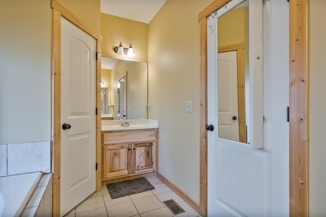 bathroom with tiled bath, tile patterned flooring, vanity, visible vents, and baseboards