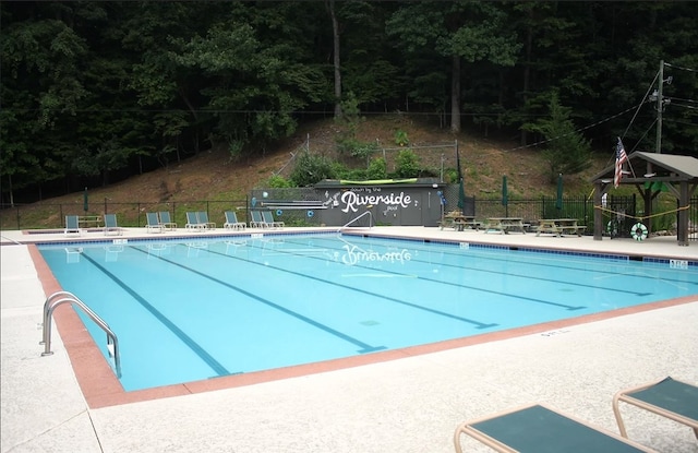 community pool with a patio and fence