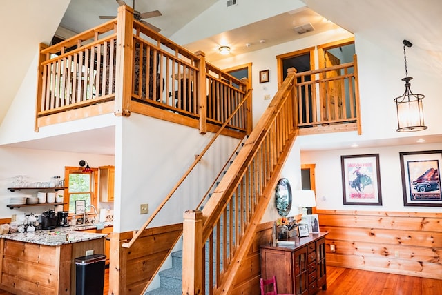 staircase with wood-type flooring and vaulted ceiling