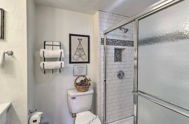 bathroom featuring a textured ceiling, vanity, toilet, and walk in shower