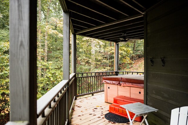 deck featuring ceiling fan and a hot tub