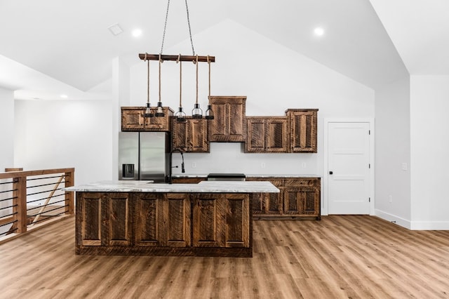 109 Lakeview Ct, Ellijay, GA 30540 - kitchen featuring stainless steel fridge, light wood-type flooring, a center island with sink, dark brown cabinetry, and high vaulted ceiling
