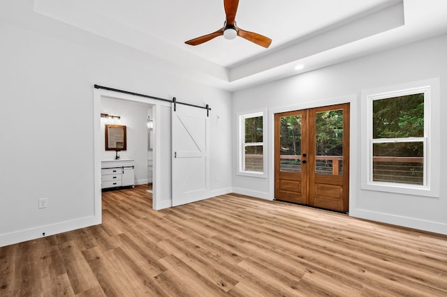 109 Lakeview Ct, Ellijay, GA 30540 - empty room with a barn door, light wood-style flooring, a tray ceiling, a ceiling fan, and recessed lighting