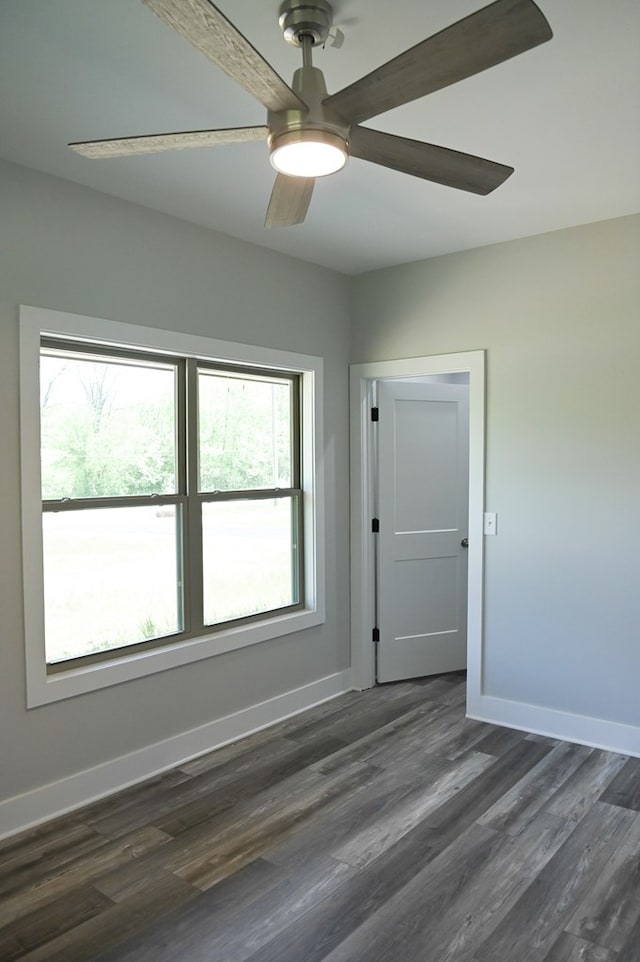 spare room with a wealth of natural light, dark hardwood / wood-style flooring, and ceiling fan