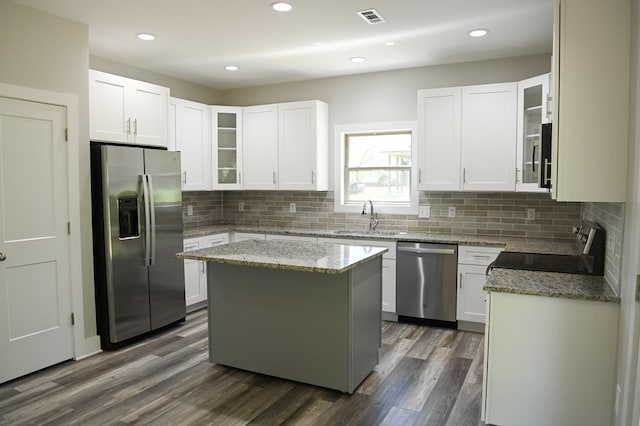 kitchen featuring a kitchen island, dark wood-type flooring, stainless steel appliances, and white cabinets