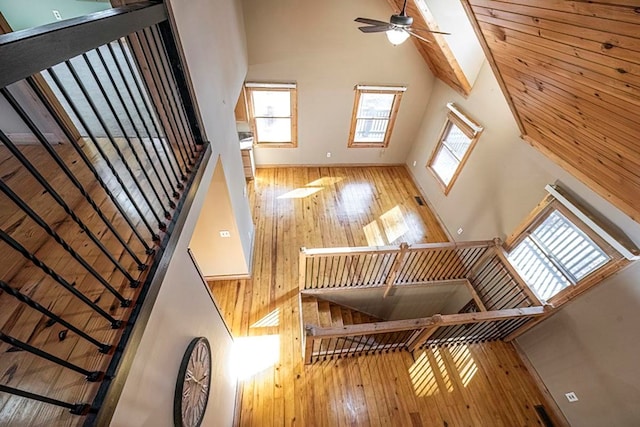 stairway featuring hardwood / wood-style flooring, ceiling fan, and high vaulted ceiling