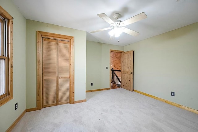 unfurnished bedroom featuring light carpet, ceiling fan, and a closet