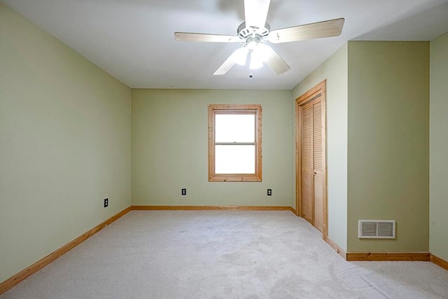 empty room featuring light colored carpet and ceiling fan