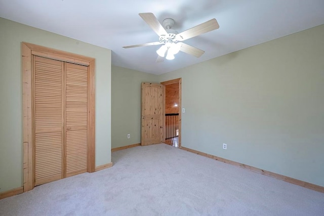 unfurnished bedroom featuring light carpet, a closet, and ceiling fan