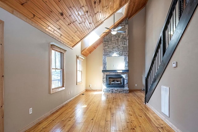 unfurnished living room with wood ceiling, high vaulted ceiling, light wood-type flooring, ceiling fan, and a fireplace