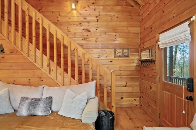 stairs with wooden walls and wood finished floors