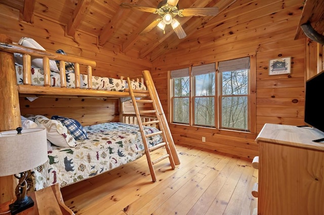 bedroom featuring wooden ceiling, vaulted ceiling with beams, wood walls, and light wood finished floors