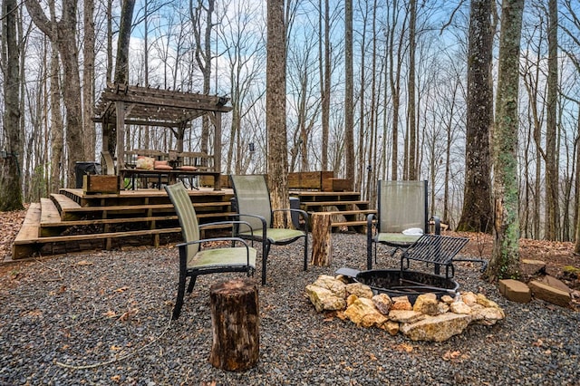 view of yard with a deck and an outdoor fire pit