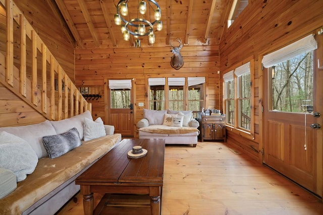 living room with wooden ceiling, wood walls, and vaulted ceiling with beams