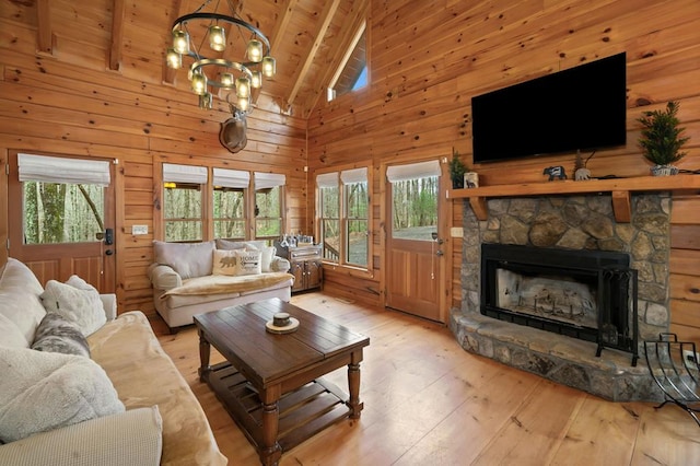 living room featuring beam ceiling, plenty of natural light, wood walls, and wood-type flooring