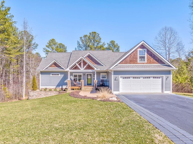 craftsman inspired home with a garage, covered porch, driveway, and a front lawn