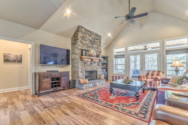 living room featuring a fireplace, light wood finished floors, a ceiling fan, high vaulted ceiling, and baseboards