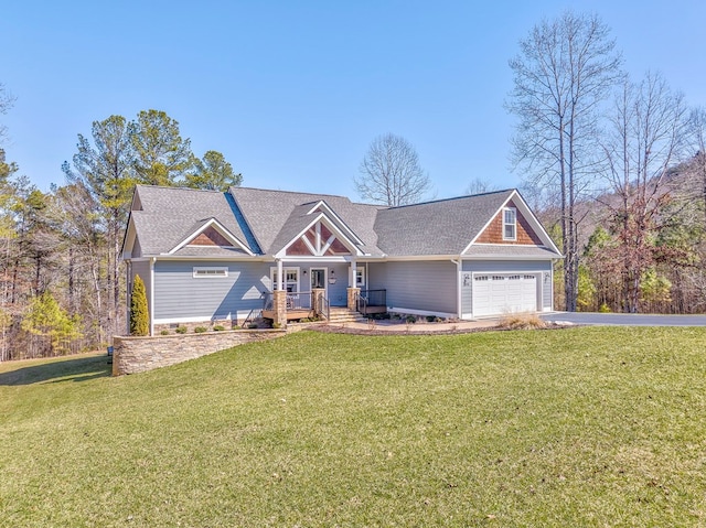 craftsman house with an attached garage, driveway, and a front lawn