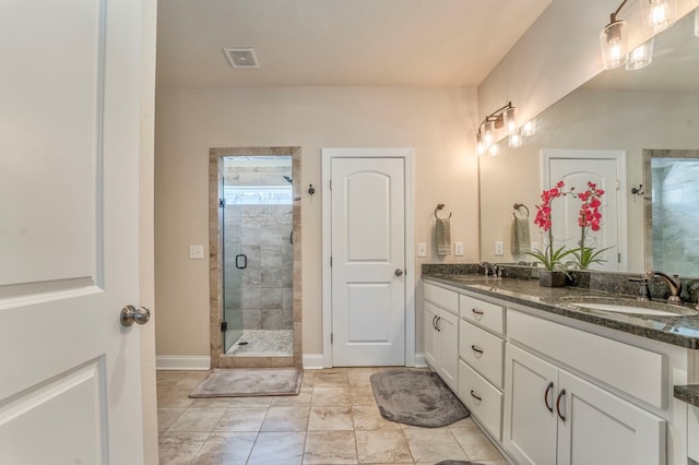 bathroom with visible vents, a sink, a shower stall, and double vanity