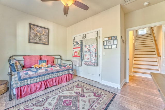 bedroom with ceiling fan, light wood finished floors, and baseboards