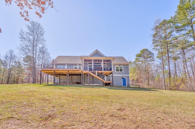 rear view of property featuring stairway, a lawn, a wooden deck, and a sunroom