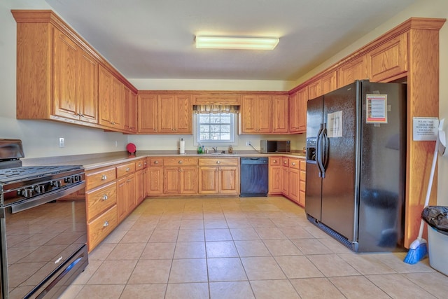 kitchen with black appliances, light tile patterned floors, light countertops, and a sink