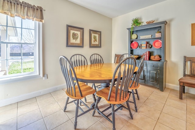 dining space with light tile patterned floors and baseboards