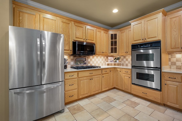 kitchen with light brown cabinetry, light countertops, glass insert cabinets, appliances with stainless steel finishes, and tasteful backsplash