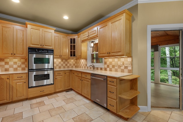 kitchen with light countertops, backsplash, appliances with stainless steel finishes, and a sink