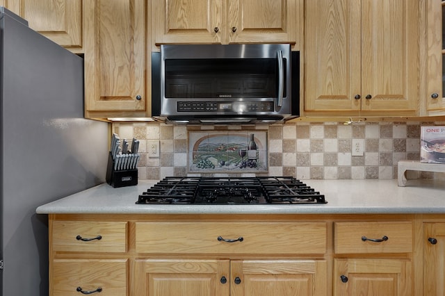 kitchen featuring stainless steel appliances, tasteful backsplash, light brown cabinets, and light countertops