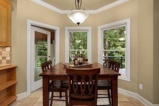 dining space with baseboards and crown molding