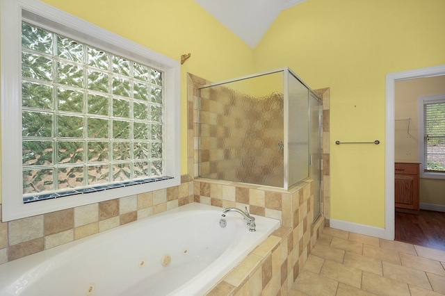 bathroom with tile patterned floors, a shower stall, baseboards, a whirlpool tub, and vaulted ceiling