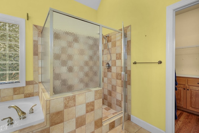 full bathroom with tile patterned floors, baseboards, a bath, and a shower stall