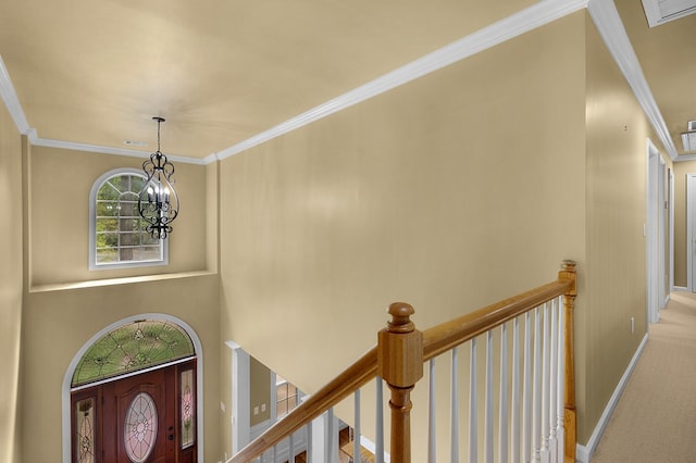 foyer entrance with baseboards, carpet floors, an inviting chandelier, and ornamental molding