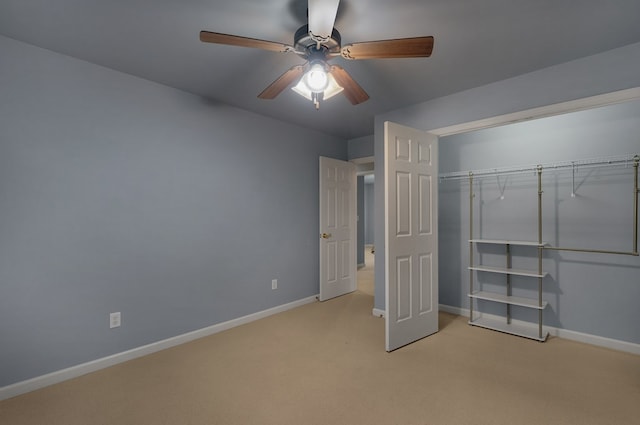 unfurnished bedroom featuring a closet, light colored carpet, baseboards, and ceiling fan