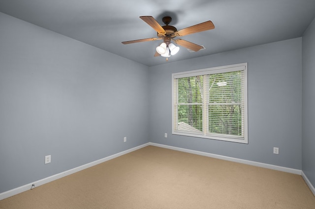 empty room featuring a ceiling fan, baseboards, and light carpet