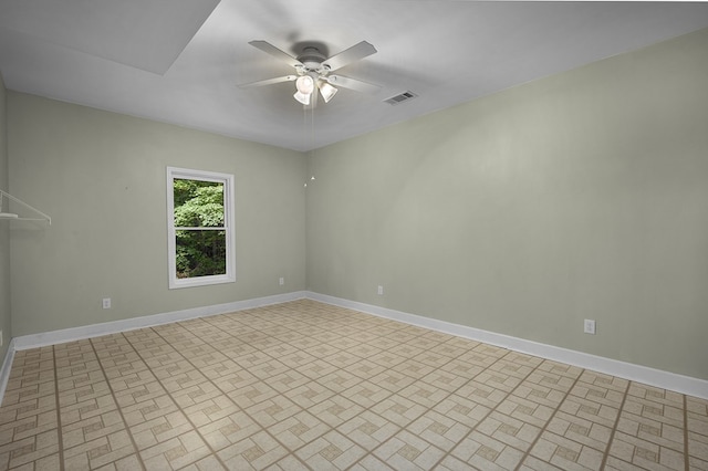 empty room with visible vents, baseboards, and ceiling fan