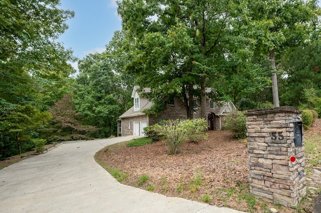 view of side of home with brick siding, concrete driveway, and an attached garage