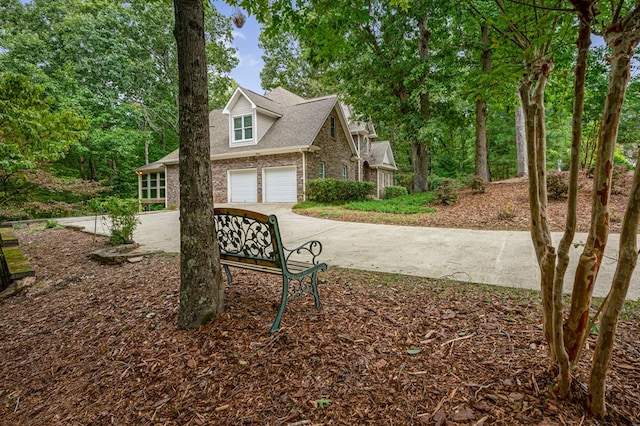 exterior space with an attached garage, brick siding, and driveway