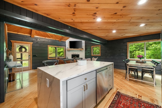 149 Happy Hollow Ln, Mineral Bluff, GA 30559 - kitchen with a tiled fireplace, light wood-style floors, wooden walls, healthy amount of natural light, and dishwasher