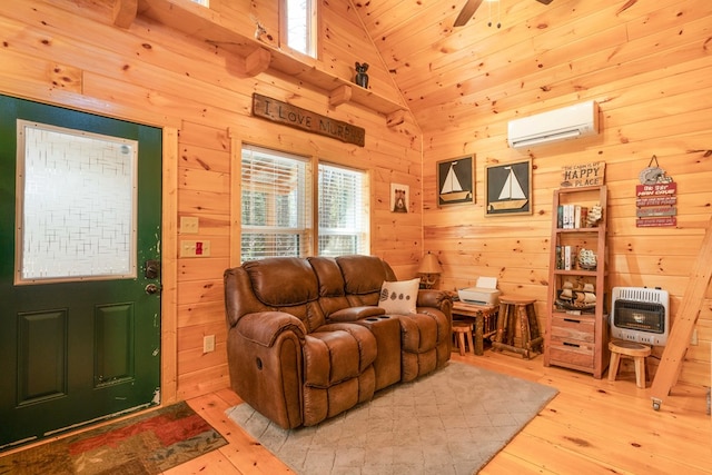 living room featuring wooden walls, heating unit, light wood-type flooring, a wealth of natural light, and a wall mounted AC