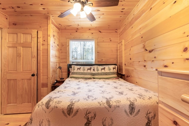 bedroom with wooden ceiling, wood walls, and ceiling fan