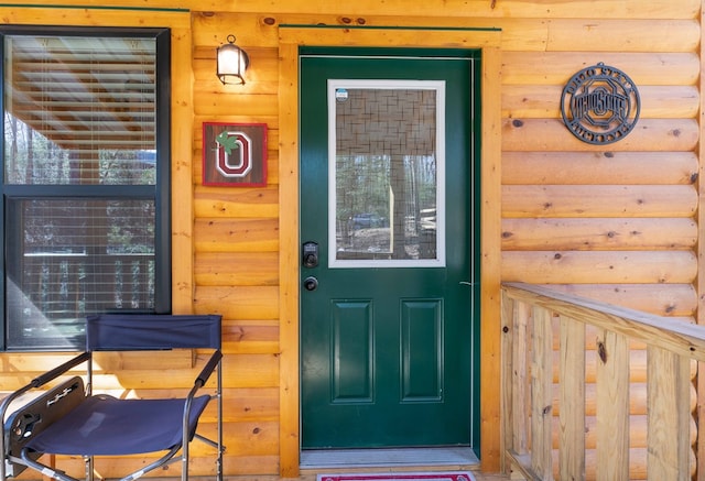 view of exterior entry with faux log siding