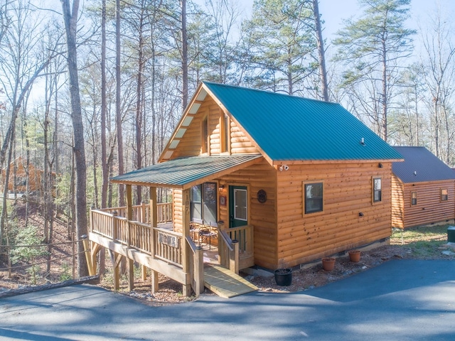 view of front of home with metal roof and log veneer siding