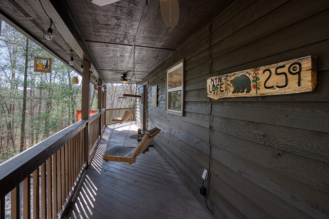 wooden terrace featuring a porch and a ceiling fan