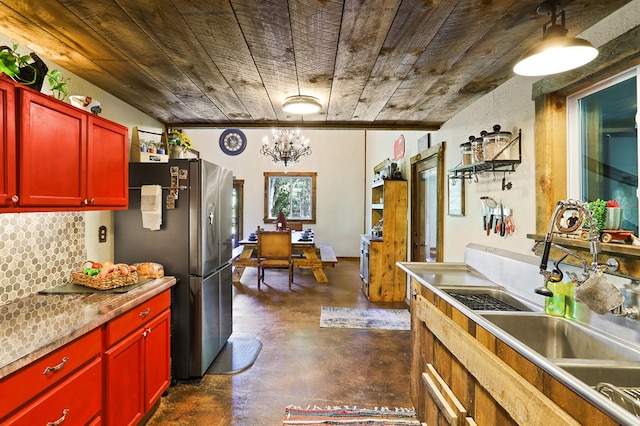 kitchen featuring sink, stainless steel fridge, backsplash, a notable chandelier, and wooden ceiling