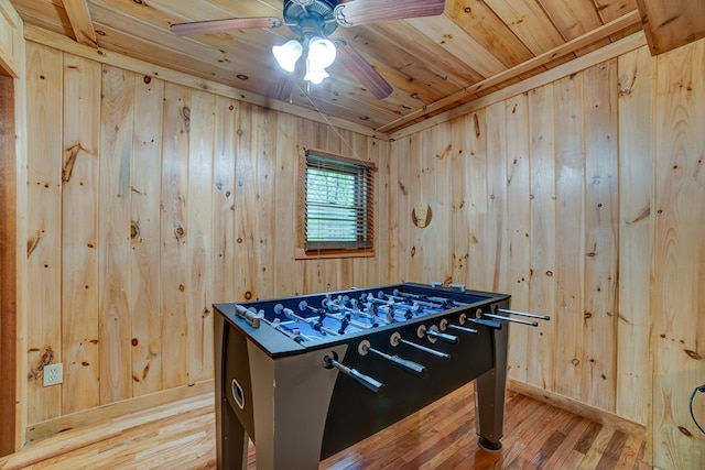 rec room featuring ceiling fan, wood ceiling, wooden walls, and light hardwood / wood-style flooring