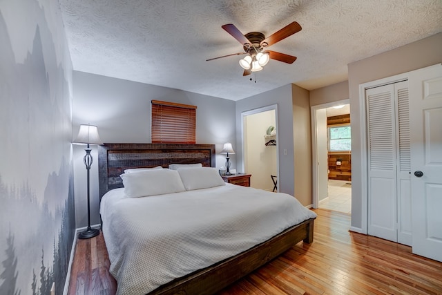 bedroom with connected bathroom, ceiling fan, a textured ceiling, a closet, and light wood-type flooring