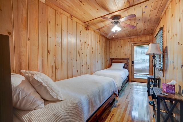 bedroom featuring hardwood / wood-style floors, ceiling fan, wooden ceiling, and wooden walls